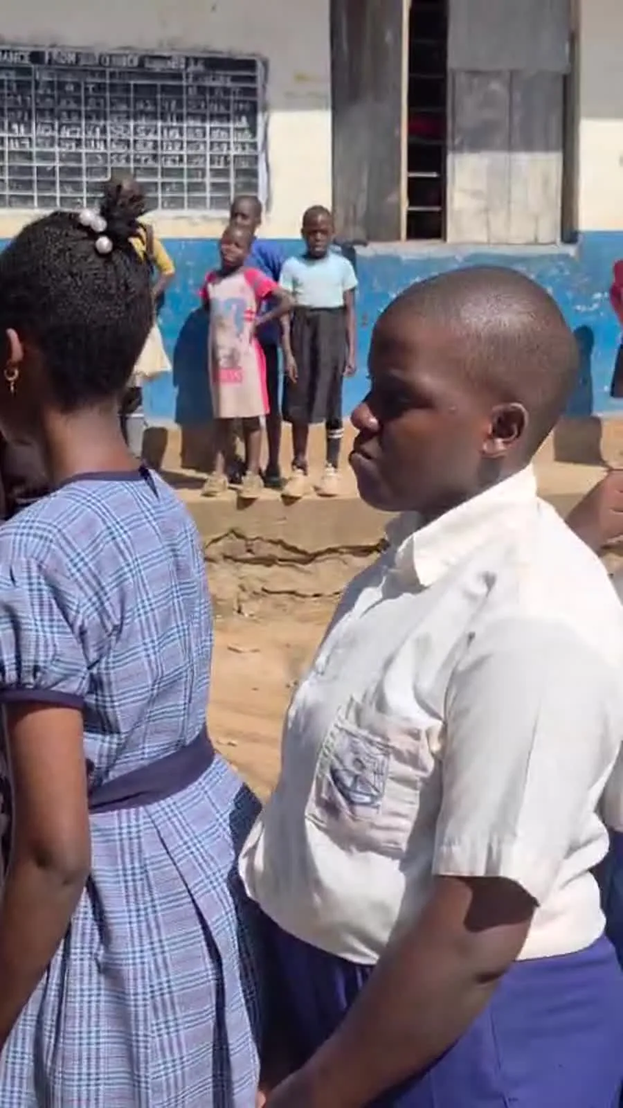 Un enfant attend près des personnes qui distribuent des produits.
